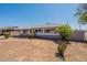 Ranch-style home featuring a desert front yard with a low brick wall, grey exterior paint and mature landscaping at 3441 W Sweetwater Ave, Phoenix, AZ 85029