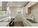 A modern kitchen featuring sleek countertops, a stainless steel range hood, and ample natural light at 3441 W Sweetwater Ave, Phoenix, AZ 85029