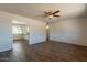 Spacious living room with beautiful hardwood floors, a ceiling fan, and a view of the kitchen at 3441 W Sweetwater Ave, Phoenix, AZ 85029