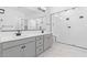 Modern bathroom featuring double sinks, sleek fixtures, and a glass-enclosed shower with a built-in bench at 37785 W Santa Maria St, Maricopa, AZ 85138