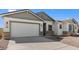A house with a two-car garage, desert landscaping, and neutral color palette for a welcoming aesthetic at 37785 W Santa Maria St, Maricopa, AZ 85138