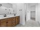 Bathroom featuring double sinks, wood cabinets, matte black hardware, and elegant tile flooring at 37805 W Santa Maria St, Maricopa, AZ 85138