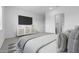 This main bedroom features an ensuite bathroom, with clean carpets and a mounted television at 37805 W Santa Maria St, Maricopa, AZ 85138