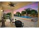 Backyard with covered patio, lounge chairs, a built-in pool with a waterfall, and landscaping at sunset at 3912 E Ellis St, Mesa, AZ 85205