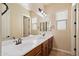 Bathroom with double sinks, a large mirror, wood cabinets, and neutral walls at 3912 E Ellis St, Mesa, AZ 85205