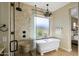 Spa-like bathroom with a rainfall shower, a freestanding tub, and stylish fixtures at 3912 E Ellis St, Mesa, AZ 85205