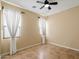 Bright bedroom features neutral walls, tile floor, ceiling fan, and two windows with white curtains at 3912 E Ellis St, Mesa, AZ 85205