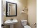 Charming powder room featuring a pedestal sink, toilet, and decorative shelves at 3912 E Ellis St, Mesa, AZ 85205