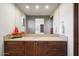 Bathroom vanity with tile flooring, a large mirror, and wooden cabinets at 39254 N 104Th Pl, Scottsdale, AZ 85262