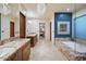 Bathroom featuring stone countertops, glass shower, and large bathtub with picture window at 39254 N 104Th Pl, Scottsdale, AZ 85262