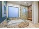 Bright bathroom with a standalone tub, glass shower, and stone countertops at 39254 N 104Th Pl, Scottsdale, AZ 85262