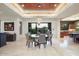 Dining room features travertine floors, a modern chandelier, seamless backyard views, and breakfast bar at 39254 N 104Th Pl, Scottsdale, AZ 85262