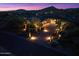 Elegant home exterior at twilight with lush landscaping, featuring inviting lighting and a circular driveway at 39254 N 104Th Pl, Scottsdale, AZ 85262