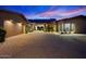 Inviting home exterior with desert landscaping, a paver driveway, and warm exterior lighting at dusk at 39254 N 104Th Pl, Scottsdale, AZ 85262