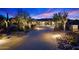 Inviting home exterior with desert landscaping, a paver driveway, and warm exterior lighting at dusk at 39254 N 104Th Pl, Scottsdale, AZ 85262
