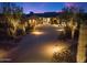 Beautiful home exterior with desert landscaping, a paver driveway, and warm exterior lighting at dusk at 39254 N 104Th Pl, Scottsdale, AZ 85262