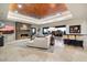 Spacious living area with stone fireplace, travertine floors, comfortable seating, and bar seating at 39254 N 104Th Pl, Scottsdale, AZ 85262
