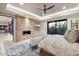Bright main bedroom featuring a stone fireplace, sitting area, and access to the backyard at 39254 N 104Th Pl, Scottsdale, AZ 85262