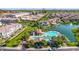 An aerial view of a community with a pool, lake, walking paths, and green spaces near commercial development at 4077 S Sabrina Dr # 14, Chandler, AZ 85248
