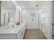 Bright bathroom featuring double vanity, framed mirrors, and a spacious walk-in shower with glass door and wood look floors at 4077 S Sabrina Dr # 14, Chandler, AZ 85248