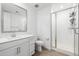 This bathroom features white cabinets, a walk-in shower with glass doors, white subway tiles, wood-look floors and modern fixtures at 4077 S Sabrina Dr # 14, Chandler, AZ 85248