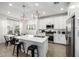 Modern white kitchen with stainless steel appliances, island with breakfast bar, and pendant lighting at 4077 S Sabrina Dr # 14, Chandler, AZ 85248