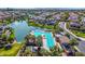 Aerial view of a community pool with palm trees, alongside a lake in a neighborhood of well-maintained homes at 4077 S Sabrina Dr # 14, Chandler, AZ 85248