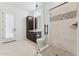 Bright bathroom featuring a glass shower, decorative tile, and dark wood cabinets at 4547 S Banning Dr, Gilbert, AZ 85297