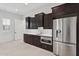 Modern kitchen with stainless steel appliances, white countertops, and dark wood cabinets at 4547 S Banning Dr, Gilbert, AZ 85297