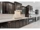 Gourmet kitchen boasts dark cabinets, stainless steel appliances, stylish countertops, and tiled backsplash at 4547 S Banning Dr, Gilbert, AZ 85297