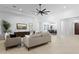A spacious living room boasting neutral decor, a modern ceiling fan and seamless flow to other living spaces at 4547 S Banning Dr, Gilbert, AZ 85297