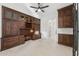 Spacious office featuring custom built-in cabinets, desk, ceiling fan, and neutral tile flooring at 4547 S Banning Dr, Gilbert, AZ 85297