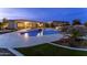 Twilight view of swimming pool and outdoor kitchen, and rock waterfall features in backyard at 4547 S Banning Dr, Gilbert, AZ 85297