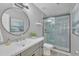 Modern bathroom with a sleek vanity, round mirror, and a glass-enclosed shower with calming blue tiles at 515 W Smoke Tree Rd, Gilbert, AZ 85233