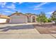 Charming single-story home with a well-manicured yard, two car garage, and a beautiful blue sky at 515 W Smoke Tree Rd, Gilbert, AZ 85233