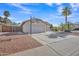 View of single-story home with large driveway, desert landscaping, basketball hoop and tile roof at 515 W Smoke Tree Rd, Gilbert, AZ 85233
