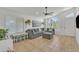 Bright living room with large sofa, tile floors, white walls, ceiling fan and natural light at 515 W Smoke Tree Rd, Gilbert, AZ 85233