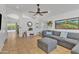 Bright living room with large sofa, tile floors, white walls, ceiling fan and natural light at 515 W Smoke Tree Rd, Gilbert, AZ 85233