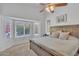 Comfortable main bedroom with large window, ceiling fan, and neutral carpet at 515 W Smoke Tree Rd, Gilbert, AZ 85233