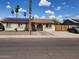 Charming single-story home with a well-maintained yard, solar panels, and mature palm trees at 5916 W Coronado Rd, Phoenix, AZ 85035