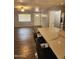 Open-concept kitchen and living area with bar seating and wood-look tile flooring at 5916 W Coronado Rd, Phoenix, AZ 85035