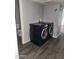 A laundry room showcases a modern washer and dryer set and wood-look floors at 5916 W Coronado Rd, Phoenix, AZ 85035