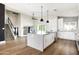 Modern kitchen with island, stainless appliances, stylish backsplash, adjacent staircase, and open-concept design at 6174 E Janice Way, Scottsdale, AZ 85254