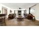 Spacious living room with stone fireplace, leather couches, ceiling fan, and decorative rug on hardwood floors at 6174 E Janice Way, Scottsdale, AZ 85254