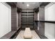 Luxurious walk-in closet with custom shelving and storage, and a central bench at 6174 E Janice Way, Scottsdale, AZ 85254