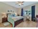 Bedroom featuring a queen-size bed, a ceiling fan, wood floors, and a view of the complex at 6535 E Superstition Springs Blvd # 146, Mesa, AZ 85206