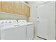 Laundry room with a white washer and dryer set, and ample overhead cabinet space at 6535 E Superstition Springs Blvd # 146, Mesa, AZ 85206