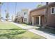 A tan, two-story apartment complex with palm trees and green lawn under a clear blue sky at 7126 N 19Th Ave # 122, Phoenix, AZ 85021
