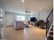 A well lit living room with tile flooring, a gray sofa, and a large television at 7126 N 19Th Ave # 122, Phoenix, AZ 85021