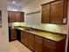 Kitchen with stone countertops, wood cabinets, tile floors, sink, and backsplash at 7609 E Indian Bend Rd # 1012, Scottsdale, AZ 85250